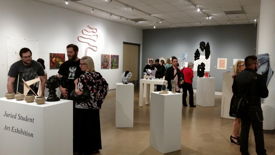 Students, alumni, faculty and staff browse the diverse range of art displayed by NEIU students at the Juried Art Exhibition