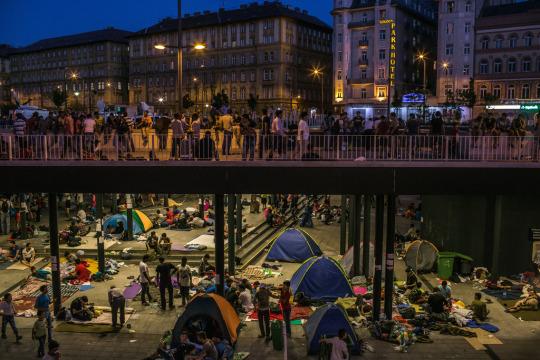 Refugee families set up camp underneath a Budapest bridge.