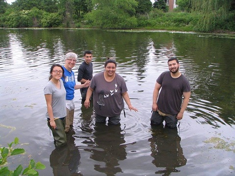 Professor Laura Sanders stands with students while conducting research. 