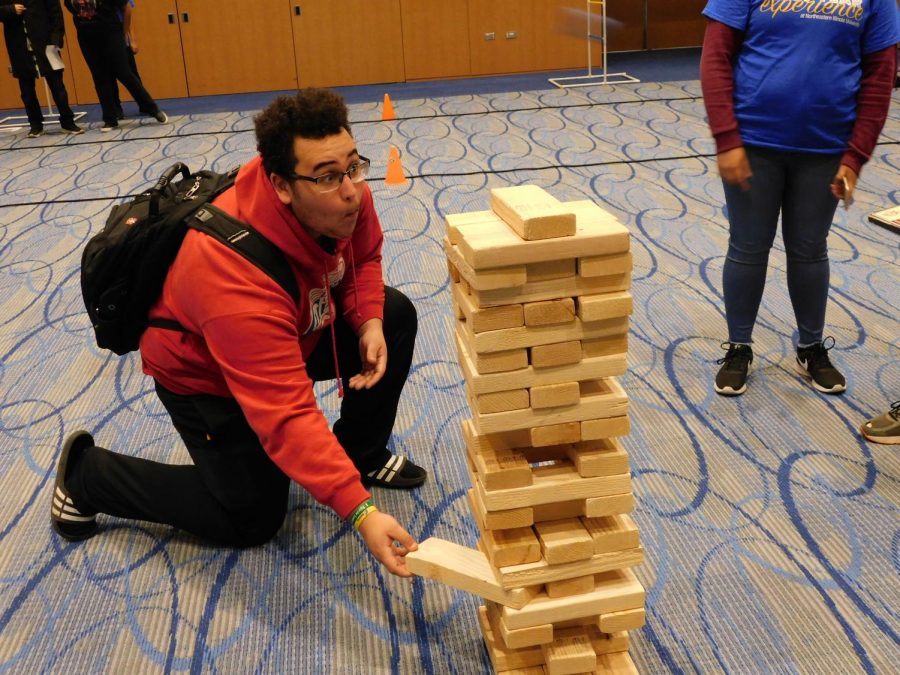 Student participating in the extra-large jenga at Eagle Fest.