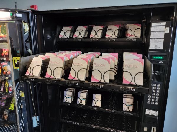 Photo of vending machine shelf  pulled out to show it stocked with boxes of Plan B