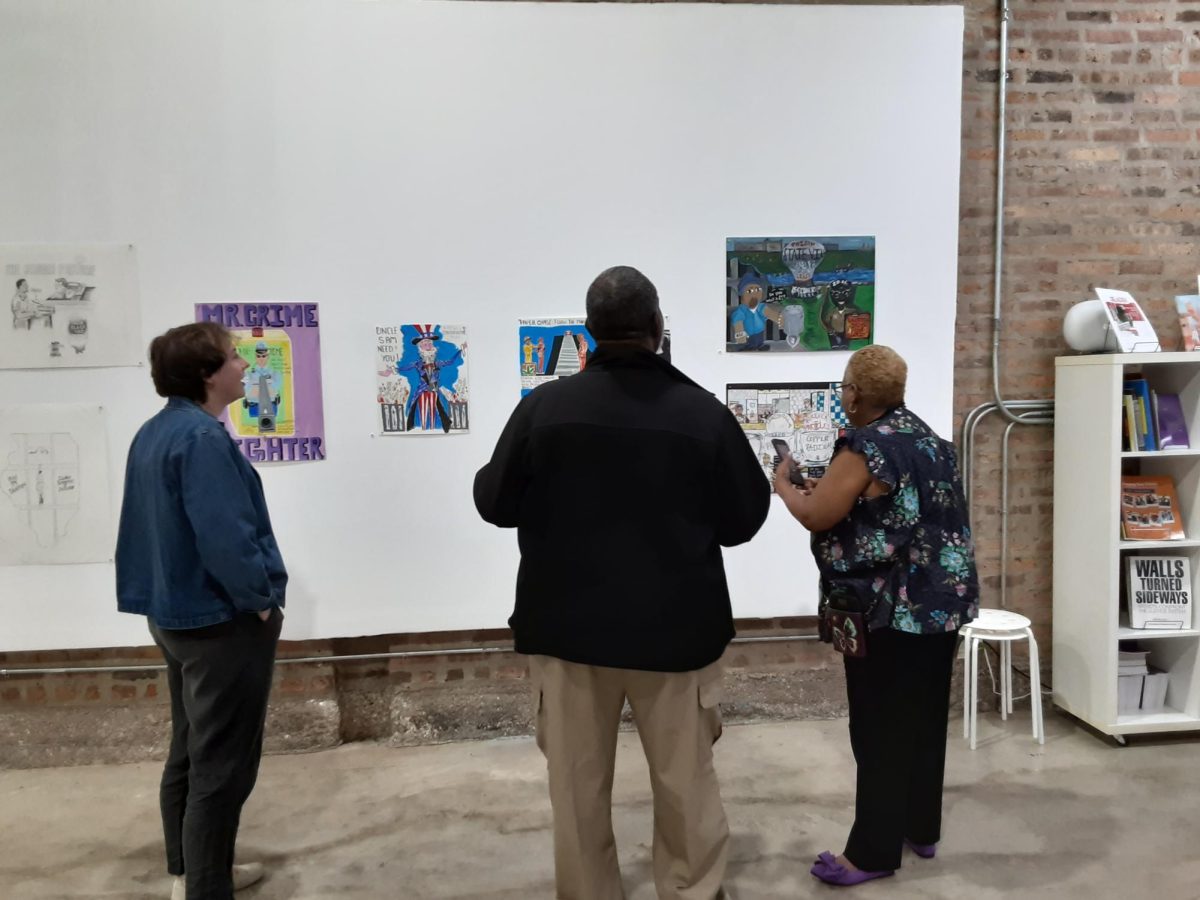 People gathered around Project Parole Illinois art displayed at Walls Turned Sideways.