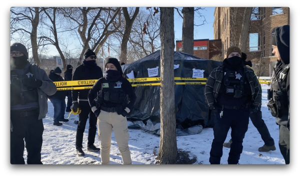 Chicago stand around a yurt as it is zoned off for destruction with signs on the yurt reading “THIS IS NOT A PERMANENT STRUCTURE.